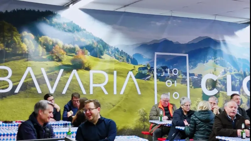 Standbild aus dem Video der BavariaCloud-Firmenbesichtigung: Gäste vor dem großen Banner mit dem Logo