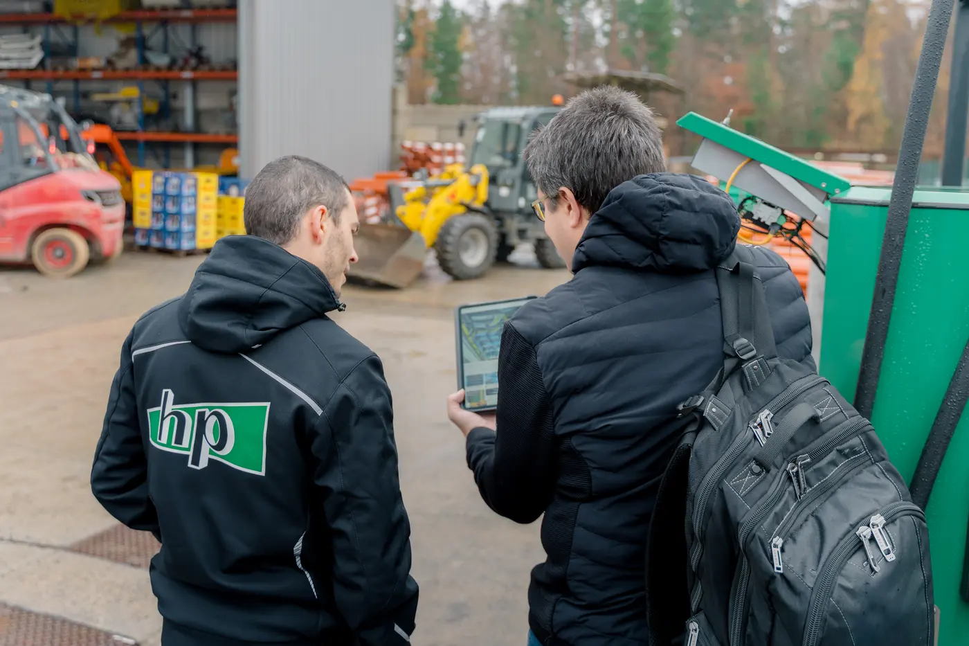 BavariaCloud-Techniker mit Laptop im Gespräch mit einem Mitarbeiter der Hermann Paul GmbH auf dem Betriebshof
