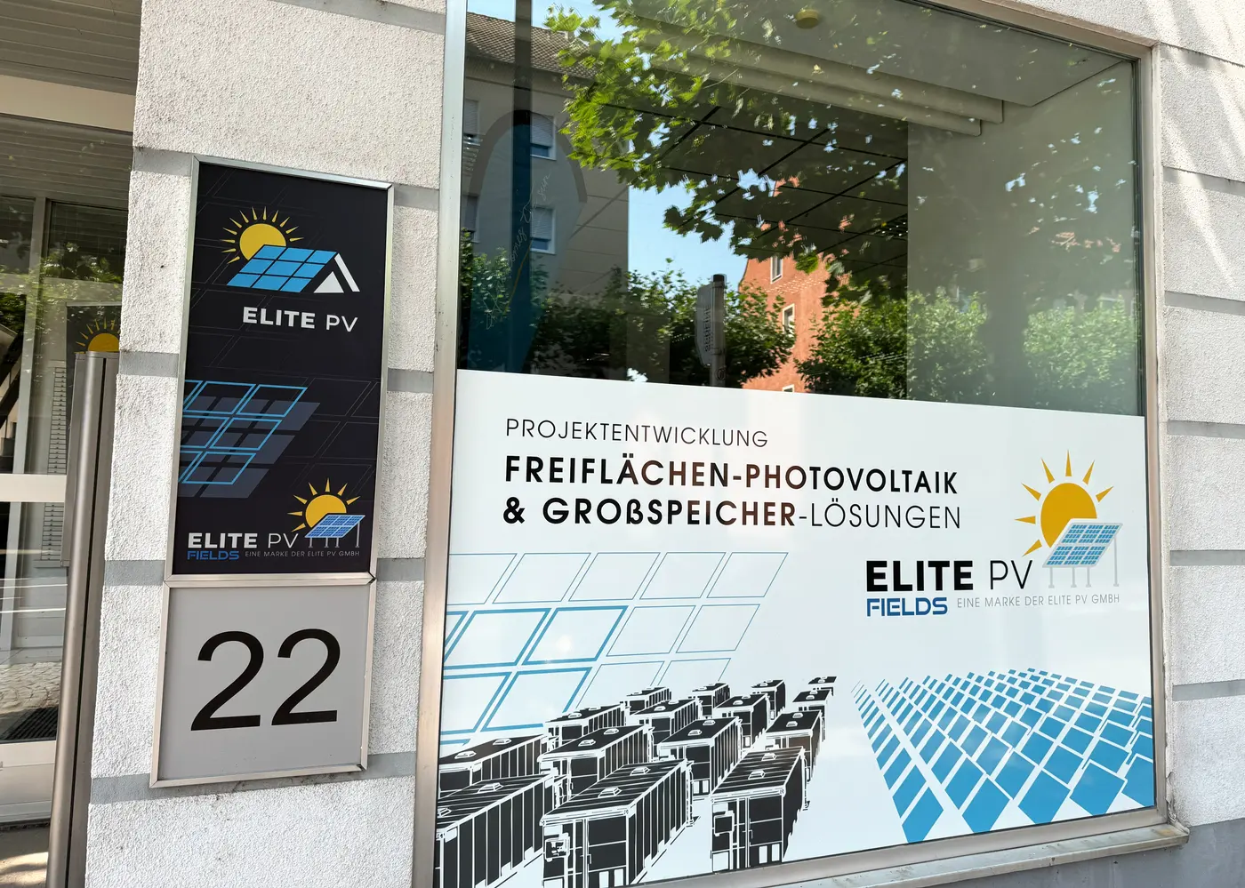 Glasfront des Elite-PV-Fields-Büros in Weiden mit Beschilderung und Folierung zu Freiflächen-Photovoltaik und Großspeichern