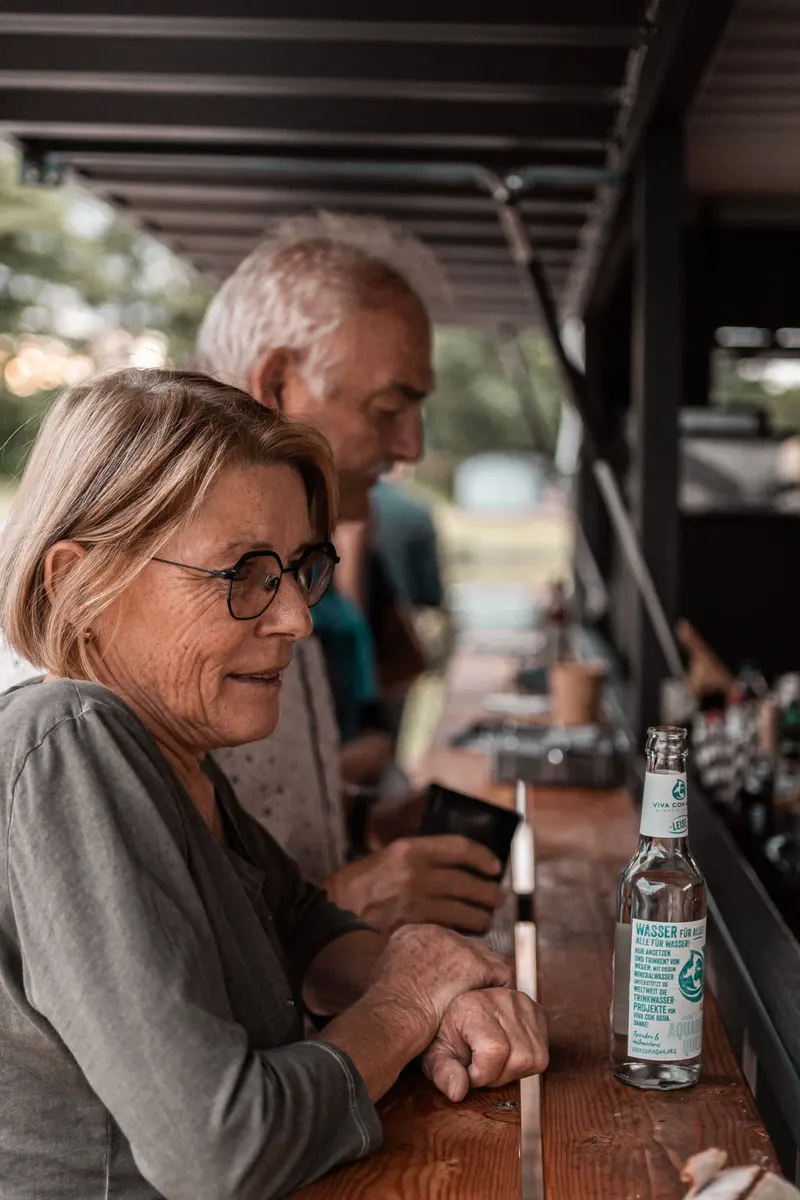 Zwei Gäste unterhalten sich an der Bar der Treibholz Beachbar