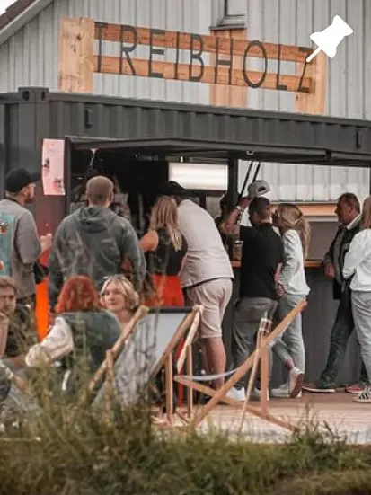 Instagram-Beitrag der Treibholz Beachbar: Gäste vor der Bar mit dem Schriftzug aus Holz