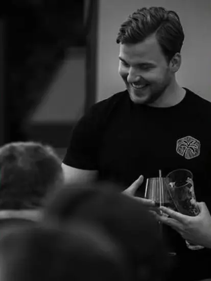 Instagram-Beitrag: lächelnder Barkeeper im Treibholz-Shirt, schwarz-weiß